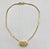 An elegant vintage Givenchy choker necklace featuring a sculptural, hexagonal G emblem suspended from a sleek gold-tone...
