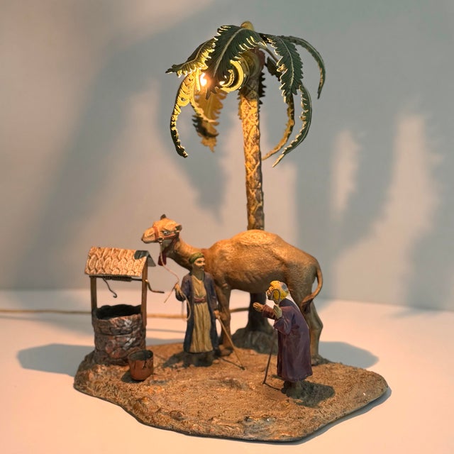 The small bulb in the palm tree illuminates an Arab scene with 2 figures, a camel and a well. Marked Austria on the...
