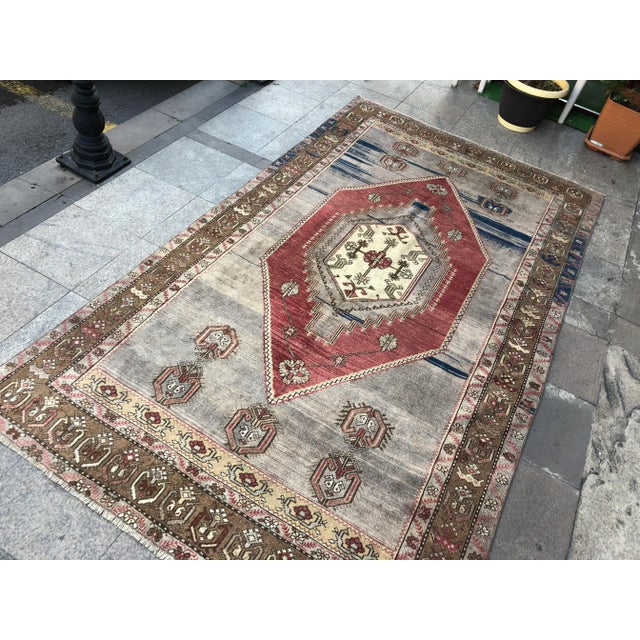 This is a vintage Turkish Oushak rug from the 1960s. The piece was hand-knotted.