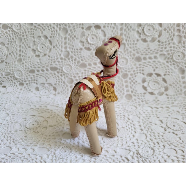 A cream leather camel, with the most charming and whimsical details. It measures 7" x 2 3/4" x 4" and would look wonderful...