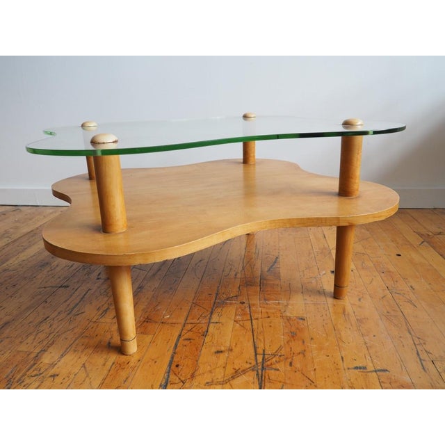 A very fun coffee table with a curvilinear / biomorphic shaped glass top very similar to the Gilbert Rohde for Herman...