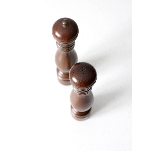 This is a mid 20th century vintage salt shaker and pepper mill. The wooden set has a turned baluster design and warm tone....