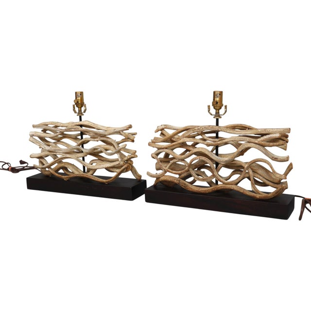A pair of large sculptural driftwood table lamps made by Palecek. Bleached wooden branches are arranged horizontally...