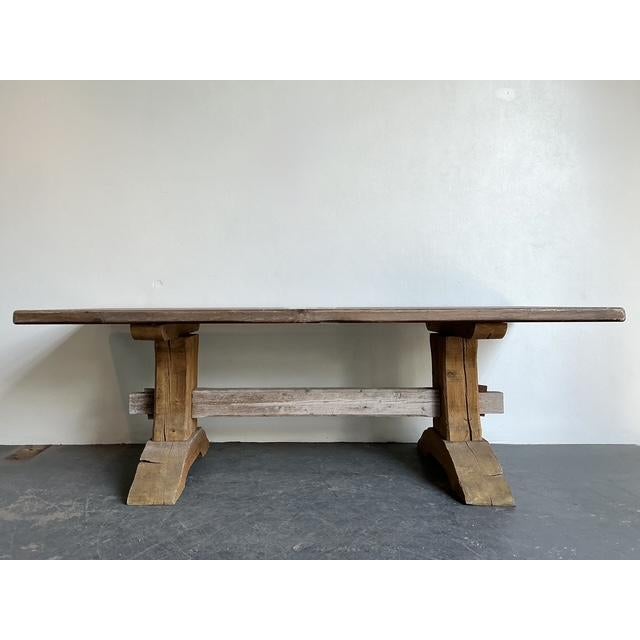 This substantial vintage trestle table is a masterpiece of rustic craftsmanship, bringing a grounded, farmhouse elegance...