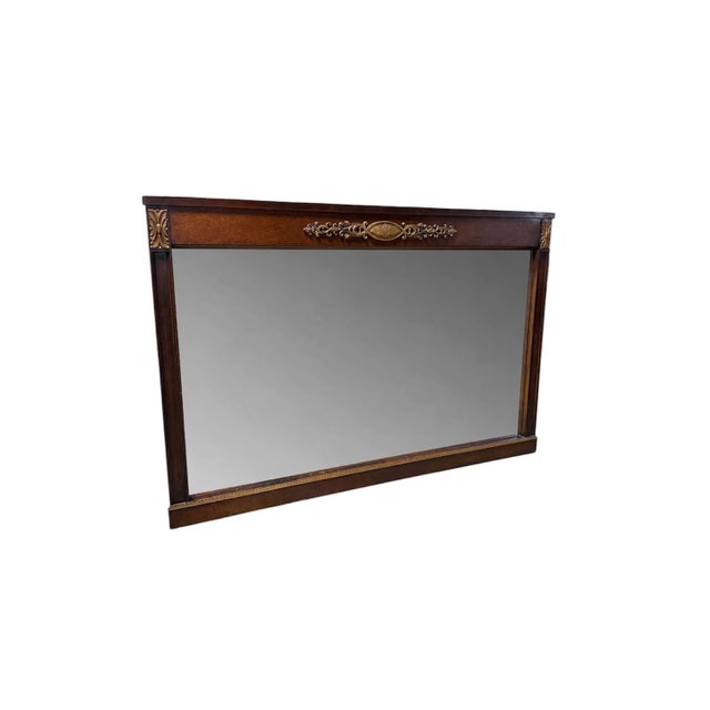 A beautifully crafted vintage wall mirror dating to the 1970s featuring a rich mahogany-toned wood frame with finely...