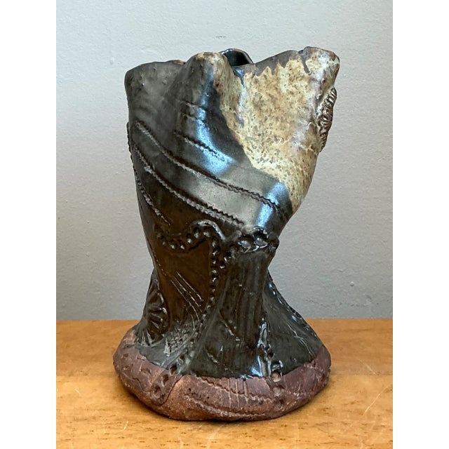 Hand-sculpted with expressive organic movement and raw tactile texture, this vintage studio pottery vase features an...
