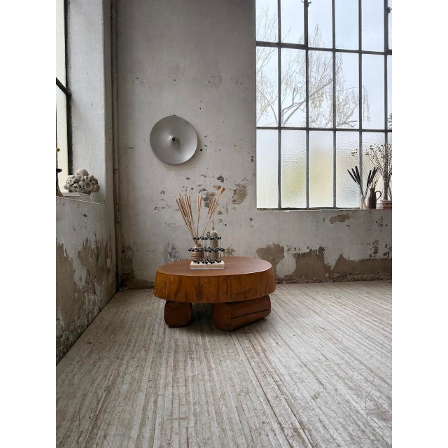 Vintage mid-20th-century Brutalist coffee table. It features a tabletop carved directly from a single tree trunk and a...