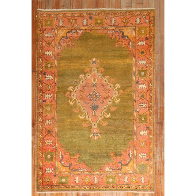 An early 20th century Antique Turkish Oushak rug highlighted by a rare green color ground. Measures: 4' x 6'6''.