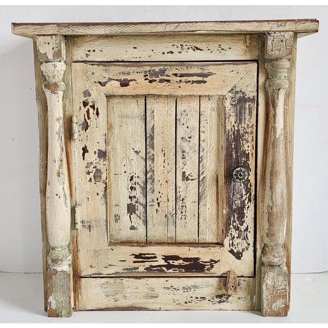 Vintage farmhouse style primitive cabinet in an distressed antique white finish. The small handcrafted cabinet with side...