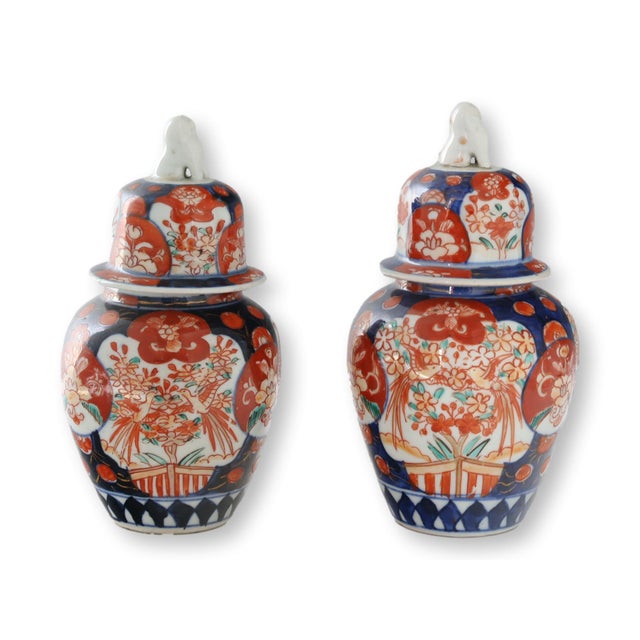 Pair of Japanese Meiji period Imari porcelain jars with foo dog finials, circa 1880. Classic iron red and cobalt blue...