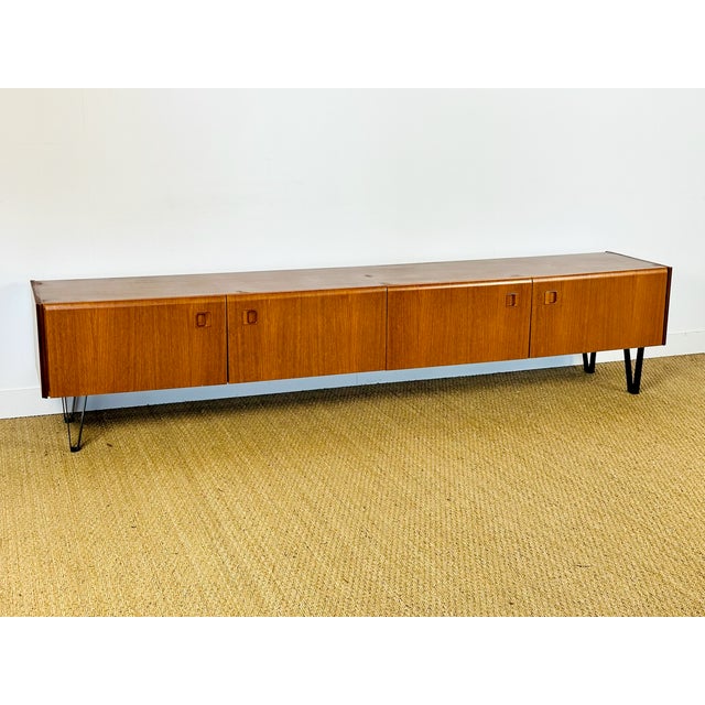 A vintage low sideboard with a clean design, emblematic of the scandinavian modernist style of the 1960s. made of teak...