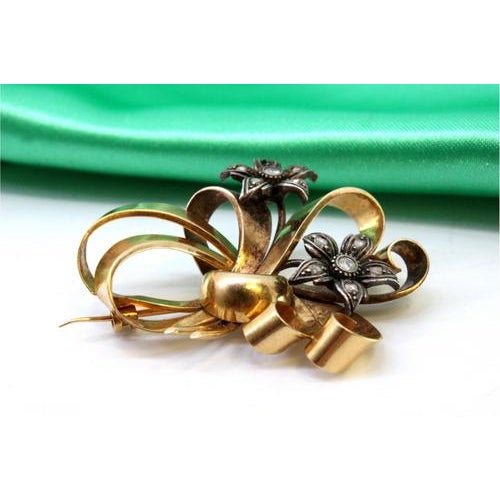 Gold and silver brooch in an interlaced shape with diamond flakes in the flowers. Metal: Gold - Silver. Origin:...