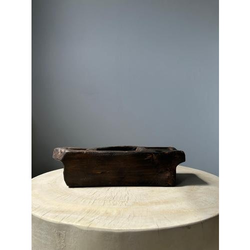 Rectangular dark brown Asian teak bowl with compartments. The natural roughness of the wood (irregularities, holes, rings...