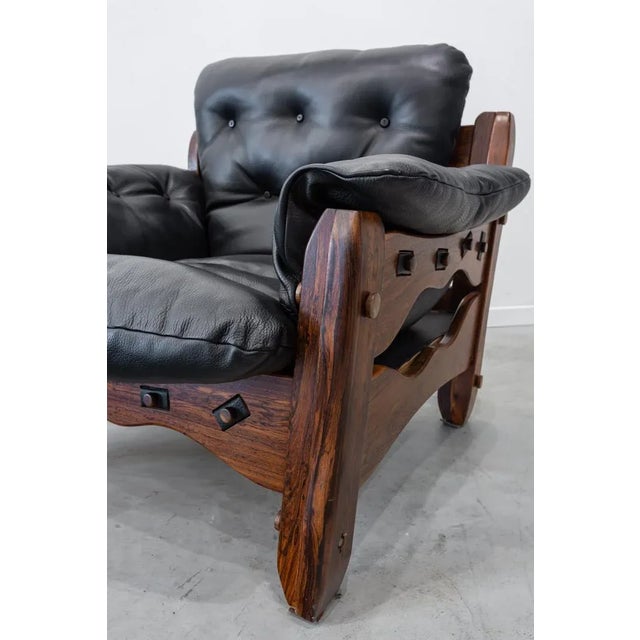 Pair of armchairs made of solid cocobolo wood and leather. The solid wood structure with a pronounced grain and rounded...
