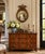 A Federal-style giltwood convex mirror crowned with a carved eagle, its wings outstretched above a laurel motif—an...