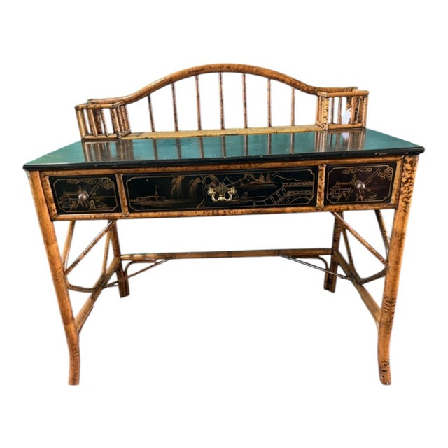 A vintage burnt bamboo and rattan desk with a black lacquer with gilt chinoiserie decoration writing surface and drawer...