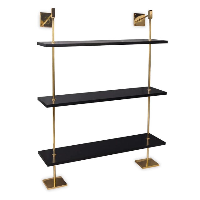 Modern multi-tier shelf in polished gold and black shelves, details urban simplicity with burnished finishes. Marais Shelf...
