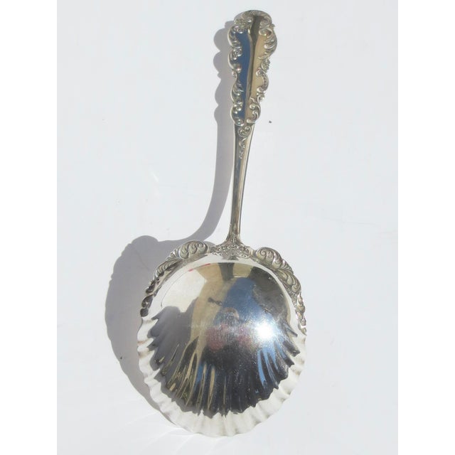 Sterling silver serving spoon by Black International circa 1915. Scalloped bowl rim with Beaux Arts designs and scrolling...