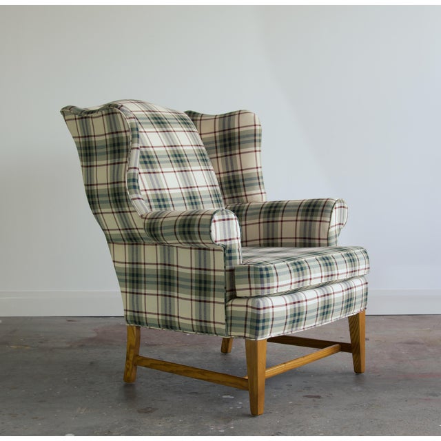 A classic camelback wingback with flat scrolled wings, softly rolled arms, and a loose boxed seat cushion. What sets it...