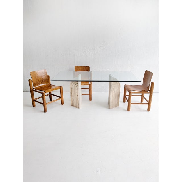 High-end and full-on luxurious dining table consisting of a glass top and two architectural travertine bases, reminding...
