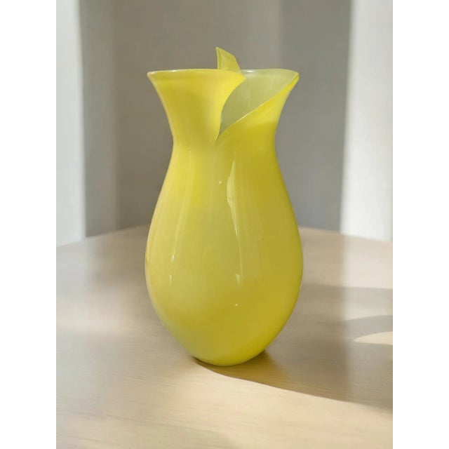 This hand-blown Italian art glass vase features a cheerful yellow color and an abstract design, adding a unique touch to...