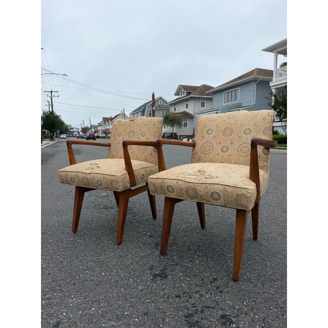 Pair of Jens Risom C-108 arm chairs. These chairs feature a sculpture carved wood armrests with an iconic mid century...