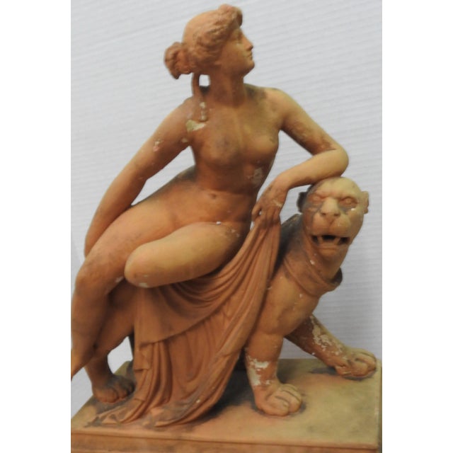 This is a stunning terracotta figure of Ariadne reclining nude on the back of a stylized panther, moving towards the...