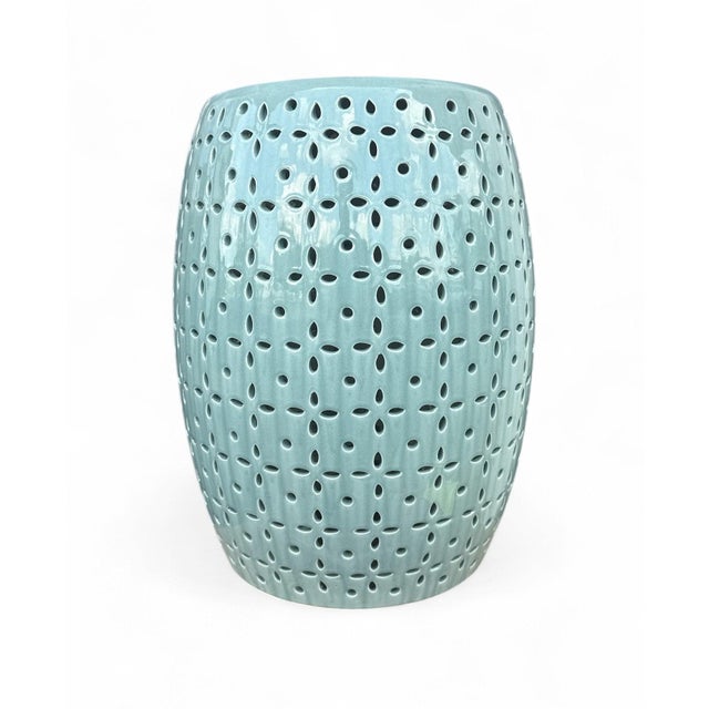 The Lovell Garden Stool is a ceramic garden stool with a barrel form and a delicate petal-flower pierced pattern in a...