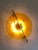 Impressive Italian Fashion Wall Light in Amber Murano Glass Disc and Brass Metal Frame Murano glass disc in amber with...