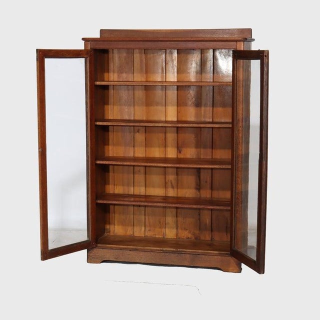 This antique Larkin Arts & Crafts oak two-door bookcase, dating to circa 1920, presents a classic example of early 20th-...