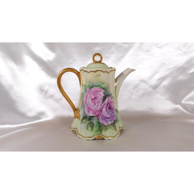 This is a signed Hutschenreuther coffee pot in an unknown pattern. It is green with three large pink flowers, gold painted...