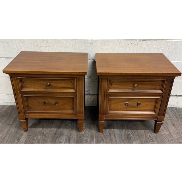 This is a stunning pair of vintage Dixie Furniture mid century traditional Neoclassical two-drawer nightstands crafted in...
