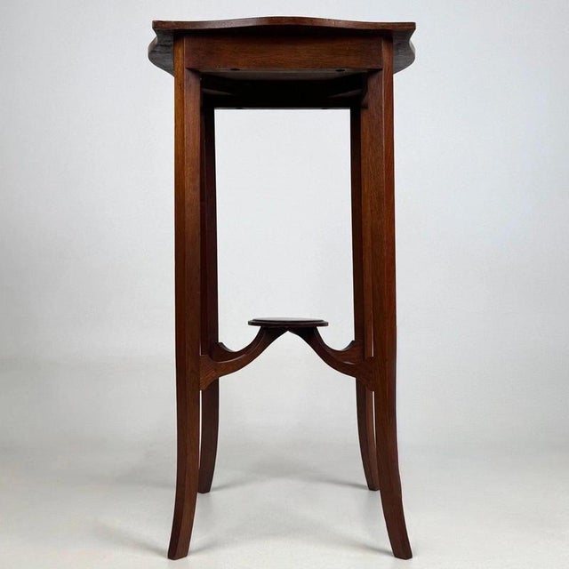A charming and beautifully crafted early 20th-century English Edwardian side table, finely constructed in mahogany and...