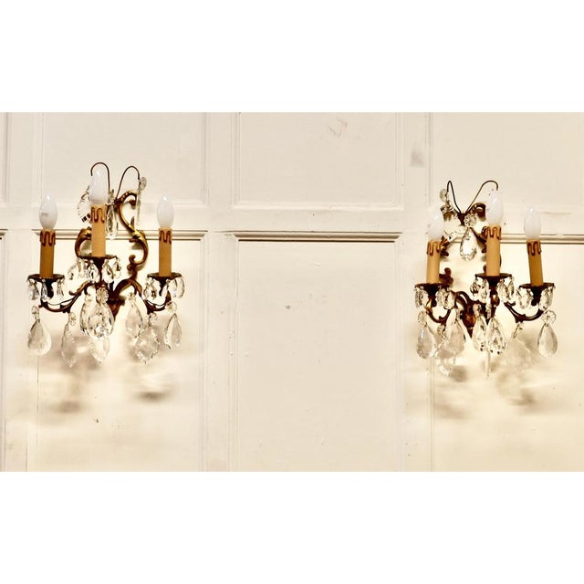 A pair of French triple wall light chandeliers These are a very pretty pair of triple wall lights, the brass lyre shaped...