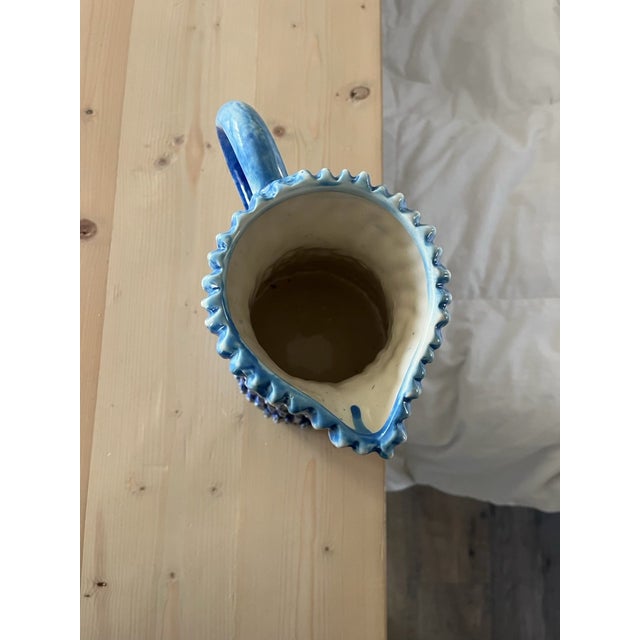 Textured pottery pitcher in light and dark blue.
