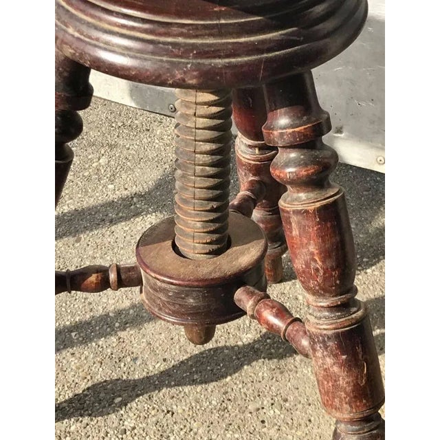 Antique adjustable piano stool. The top is leather!