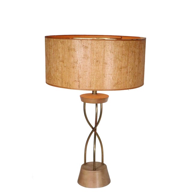 Chic architectural design Mid Century table lamp having three brass rods which intertwine as the vertical support, with a...
