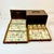 This is a lovely antique Mahjong Game Set. It features tiles that have bamboo backs with bone fronts. The tiles are...