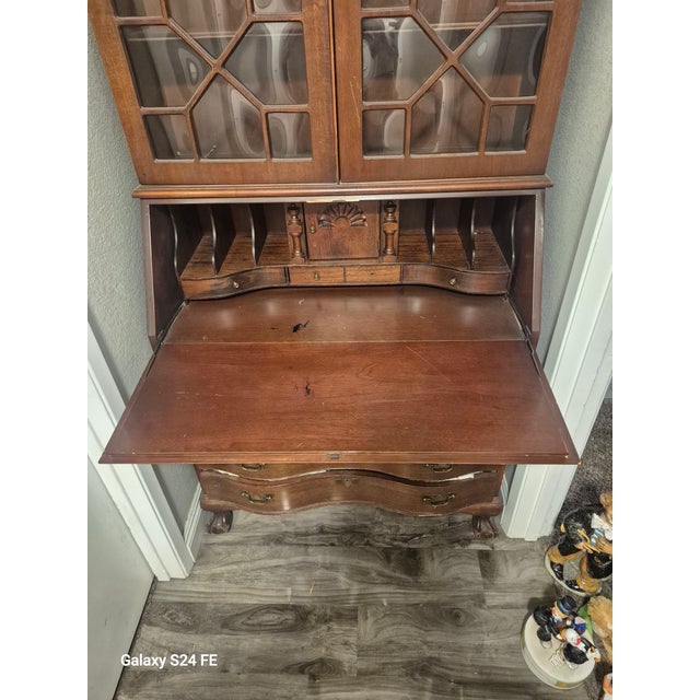 Antique secretary has 2 cabinet doors on top the doors have rounded glass in them. 4 drawers on the bottom. with a pull...