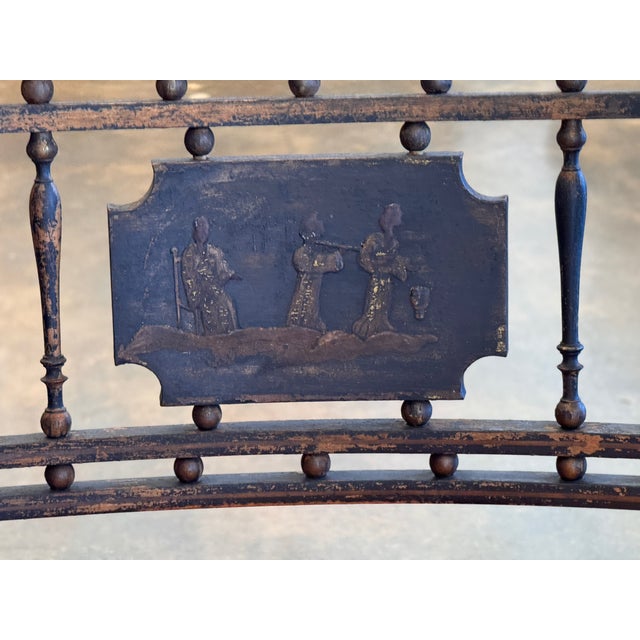 A Regency arm chair with a cane seat and a loose upholstered cushion, turned legs, and shaped arms. The back is fitted...