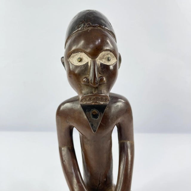 This striking hand-carved wooden figure originates from the Democratic Republic of the Congo, one of the most ethnically...