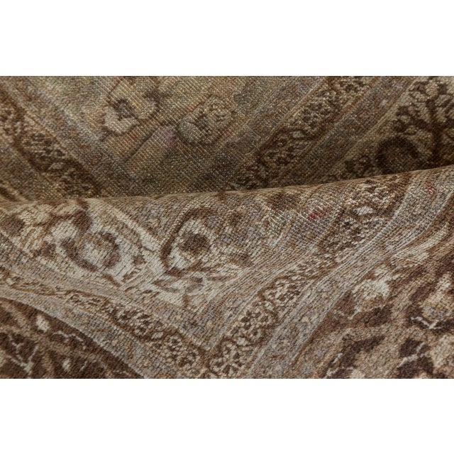 A late 19th century Persian Tabriz rug, the ivory field with an enlarged palmette and vinery trellis overall within a...