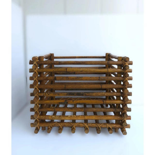 A wicker wrapped square rattan plant or tree holder cachepot. Shown holding faux plant; cachepot can hold a larger plant...