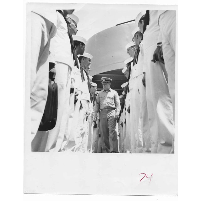 1957 black & white photo of a Navy ship with sailors being reviewed. Publication information on the back.