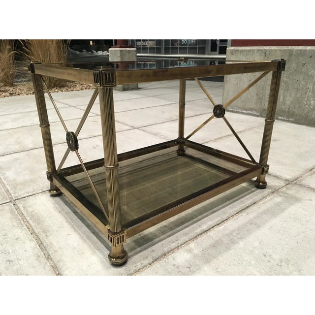 Vintage two-tier end table by Mastercraft. Neoclassical style medallions on the X-form side stretchers. Mastercraft's...