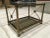 Vintage two-tier end table by Mastercraft. Neoclassical style medallions on the X-form side stretchers. Mastercraft's...