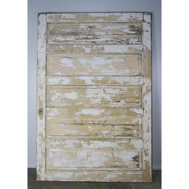 19th century French painted barn door with beautiful worn distressed finish. Cream, blue and remnants of ochre colored...
