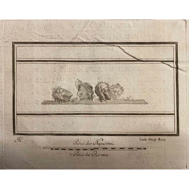 Pompeian Style Tragedy Masks from "Antiquities of Herculaneum" is an etching on paper realized by Carlo Oraty in the 18th...