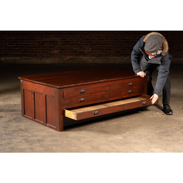 Large-format industrial flat file cabinet constructed in hardwood with a broad plank top and a bank of wide, shallow...
