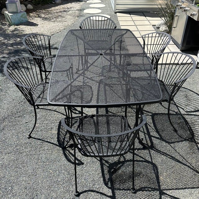 Mid Century Modern Wrought Iron Dining Table with 6 matching chairs from Carolina Forge. Table has an umbrella opening in...